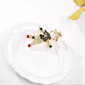 Vintage gold scarecrow reindeer brooch with pearls and colorful rhinestones on a white tray