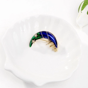 Broche lune minimaliste dorée avec émail bleu et détails d'étoiles sur plateau