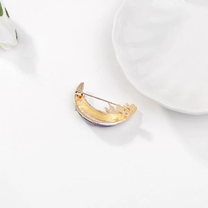 Détail de broche lune dorée avec émail violet et fermeture par épingle de sûreté sûre