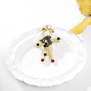 Detailed close-up of a vintage scarecrow brooch with gold plating and pearl head