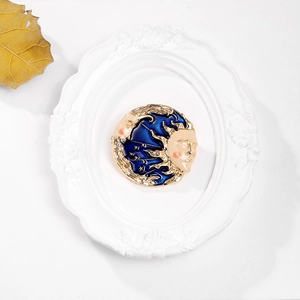 Detail shot of vintage celestial sun and moon enamel brooch on elegant white frame