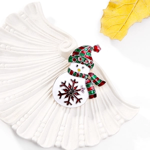 Detail van de emaille sneeuwpop broche met rood-groene geruite muts en kerst sneeuwvlok
