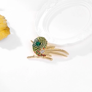 Broche oiseau exquise avec émail coloré et cristaux sur une base de branche dorée
