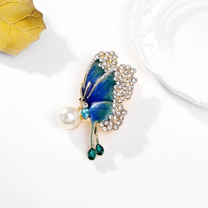 Elegant butterfly brooch with blue enamel wings, white pearl and green crystal accents