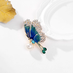Elegant butterfly brooch with blue enamel wings, white crystals and large pearl drop detail