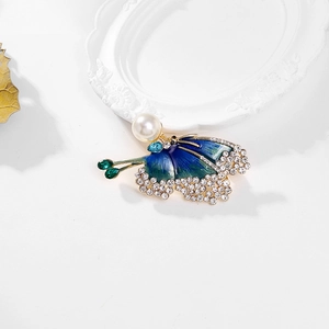 Golden butterfly brooch with blue enamel wings, pearls and sparkling rhinestones