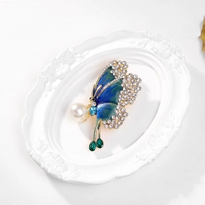 Detailed macro view of enamel butterfly brooch with rhinestones and white pearl