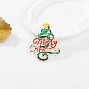 Broche sapin de Noël avec émail vert et strass rouges sur un élégant support blanc