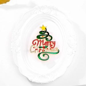 Détail de la broche sapin de Noël avec émail vert et strass rouges Merry Christmas