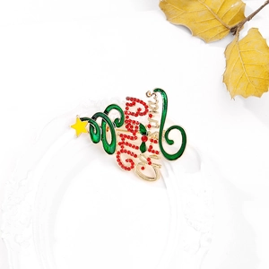 Détail de la broche sapin de Noël avec émail vert, strass rouges et texte doré Merry Christmas