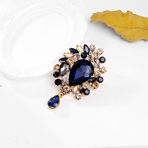 Detailansicht der Vintage-Brosche mit blauem Tropfenkristall und goldfarbener Blumenfassung