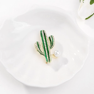 Dettaglio macro della spilla a cactus in smalto con strass brillanti e perla bianca