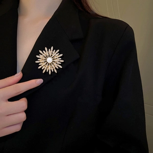 Elegant gold sunflower brooch with pearls and rhinestones on a black suit jacket