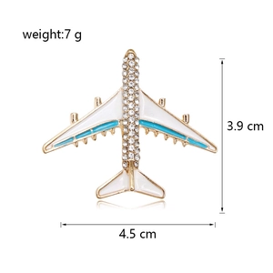 Detailed size view of an airplane brooch with enamel and crystals, 4.5 cm by 3.9 cm
