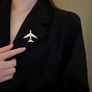 Exquisite airplane brooch with blue enamel and rhinestones on a black suit lapel