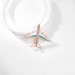 Macro detail of alloy airplane brooch with blue enamel and crystal rhinestones