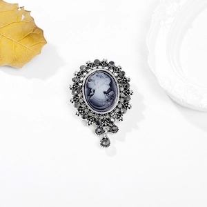 Vintage Victorian cameo brooch with crystal tassel in silver-toned alloy on white backdrop