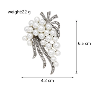 Detail view of silver grape brooch featuring white pearls and sparkling crystal leaves