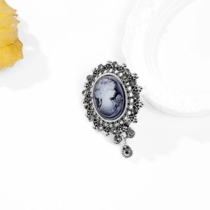 Detailed close-up of vintage cameo brooch with dark grey rhinestones and teardrop pendant