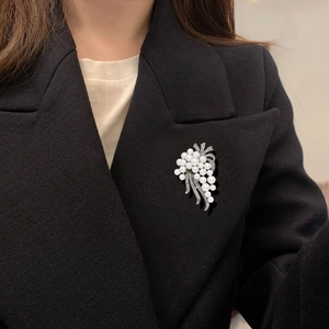 Elegant silver grape cluster brooch with pearls and rhinestones on a black suit jacket