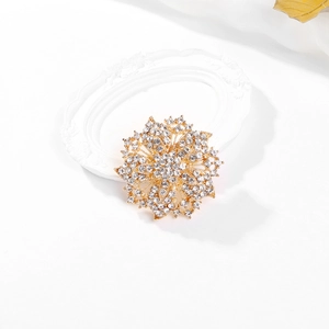 Macro detail of luxury crystal floral brooch with sparkling rhinestones on golden base