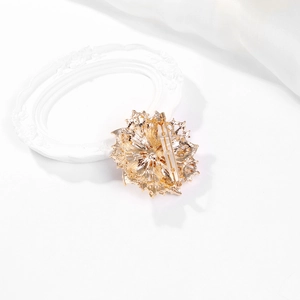 Detailed back view of a gold crystal brooch showing secure pin and floral metal base