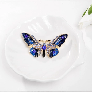 Exquise broche papillon plaquée or avec ailes en émail bleu et strass scintillants