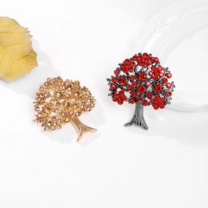 Détails de broches en forme d'arbre avec cristaux champagne et rouges sur fond blanc