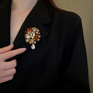 Vintage crystal flower brooch with champagne rhinestones on black blazer lapel