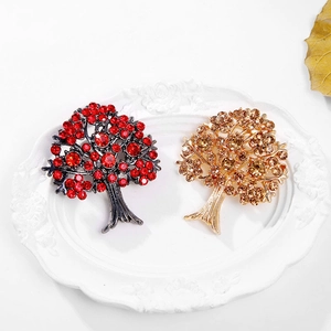 Broches d'arbres exquises avec cristaux rouges et champagne sur un plateau vintage