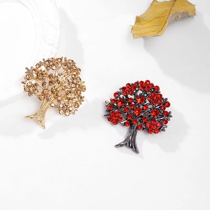 Détail de broches arbres en cristaux colorés dorés et noirs avec texture de branche