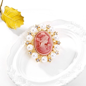 Macro detail of Victorian cameo brooch with pink relief and pearls in a vintage setting