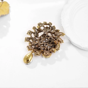 Detailed back view of vintage sun flower brooch with safety pin and teardrop crystal