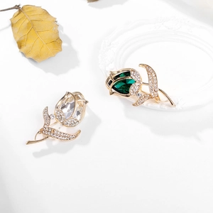 Elegante set di spille a tulipano dorate con smeraldo e cristalli bianchi su bianco