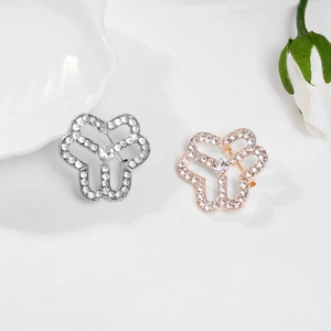 Close-up of silver and rose gold floral brooches with sparkling pavé crystals