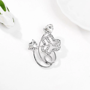 Close-up of silver flower brooch with white crystals and sparkling water drop gems