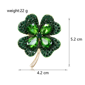 Macro shot of green clover brooch with sparkling rhinestones and crystal leaves
