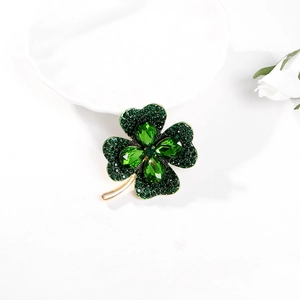 Elegant gold four-leaf clover brooch with green crystal stones and rhinestones