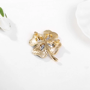 Detailed back view of gold four-leaf clover brooch with rhinestones and pin fastener