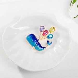 Detail of blue enamel whale brooch with colorful teardrop crystal balloons on shell tray