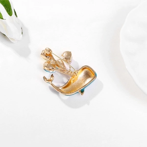 Cartoon blue whale brooch with gold plating and blue enamel details on white background