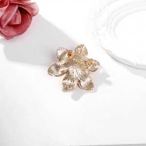 Vue arrière détaillée de la broche fleur dorée montrant l'épingle et la texture