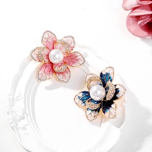 Détails des broches fleurs en émail avec perles et cristaux sur un plateau décoratif