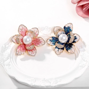 Détail de la broche fleur en émail avec perle centrale et strass étincelants