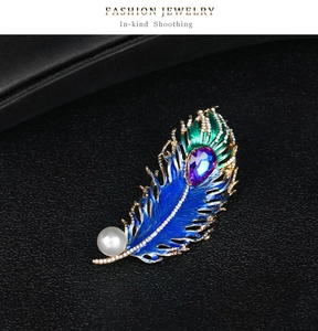 Detail of peacock feather brooch with blue enamel inlay and sparkling rhinestones
