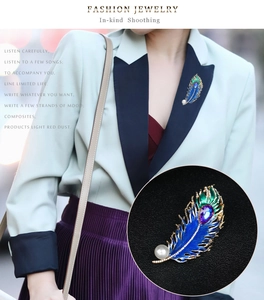 Detail of peacock feather brooch with colorful enamel, rhinestones and pearl on a suit
