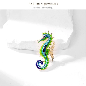 Detailed close-up of seahorse brooch with blue-green enamel and sparkling rhinestones