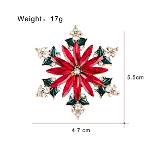Broche flocon de Noël avec cristaux rouges et émail vert sur base en alliage doré