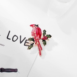 Detailed view of cardinal bird brooch with red enamel and sparkling crystal accents