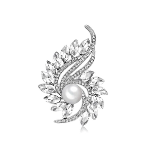 Elegant silver feather brooch with sparkling crystals and a large center pearl on white background